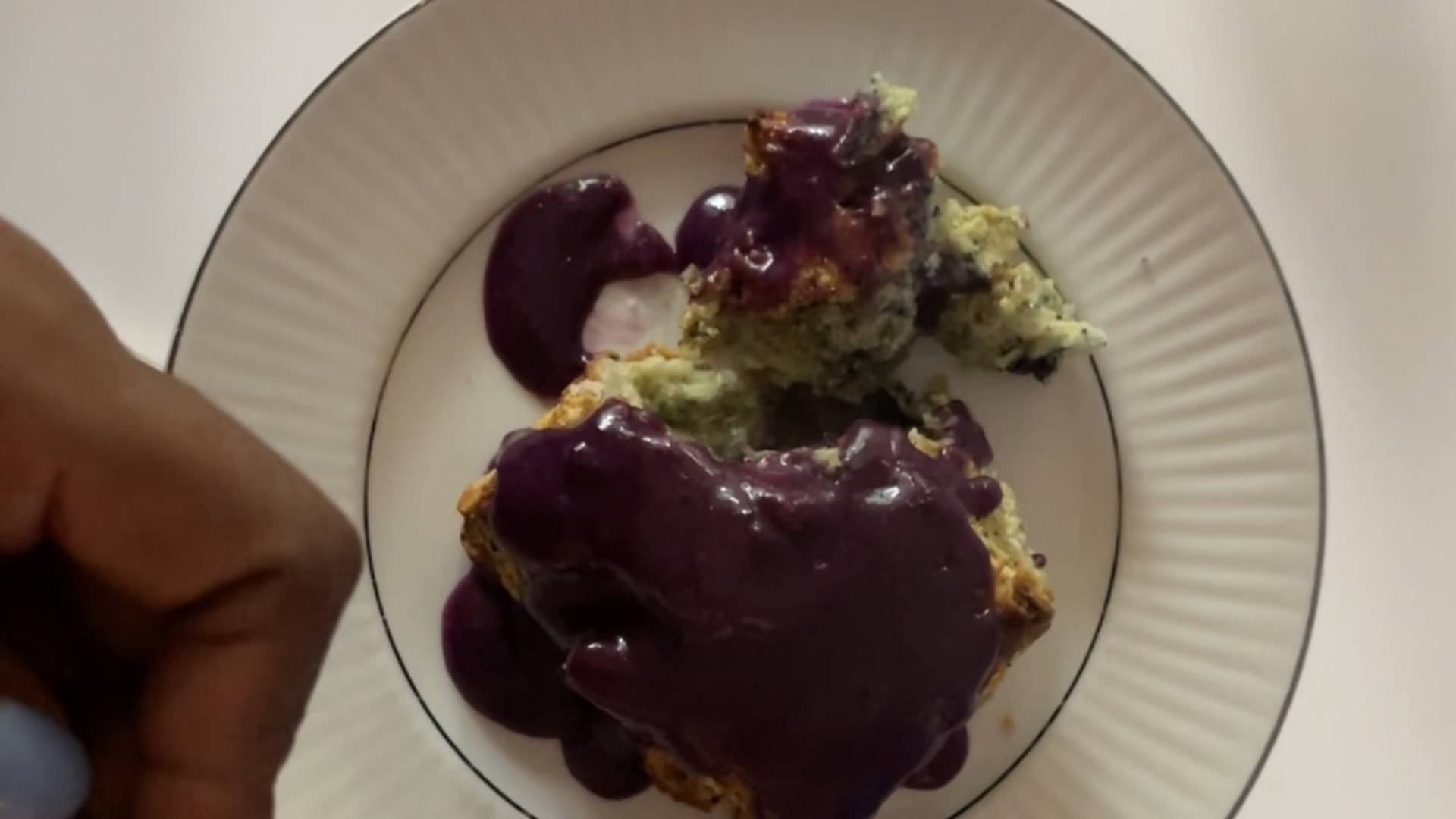 Blueberry biscuit with blueberry glaze with a corner piece broken off