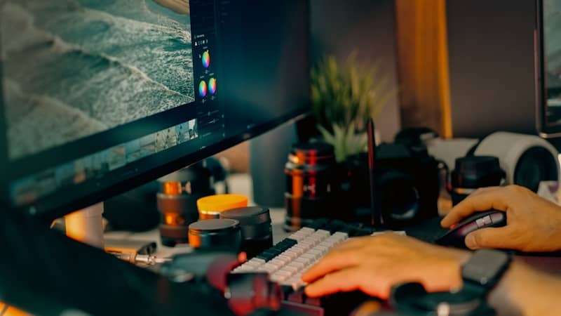 Hands typing on keyboard near computer monitor