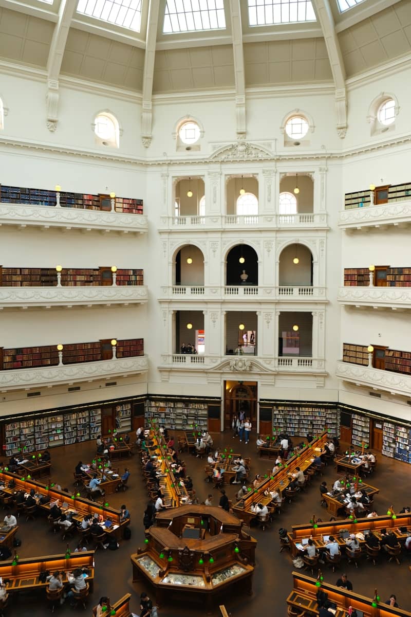 People reading at tables in a grand library