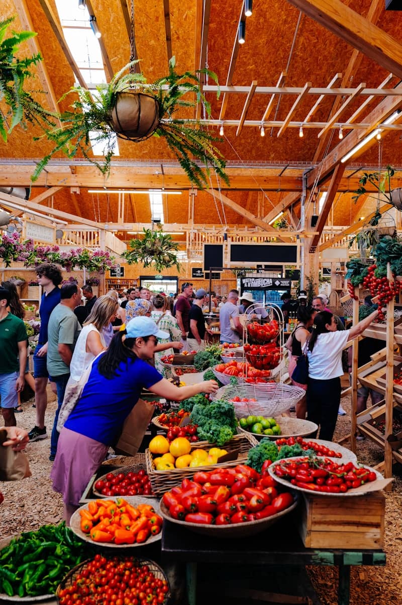 People shopping at a vibrant farmers market with fresh produce.