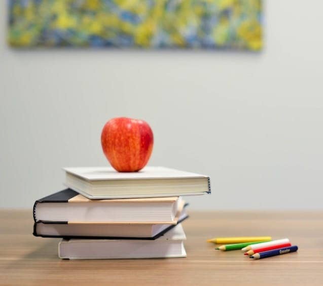 red apple fruit on four pyle books