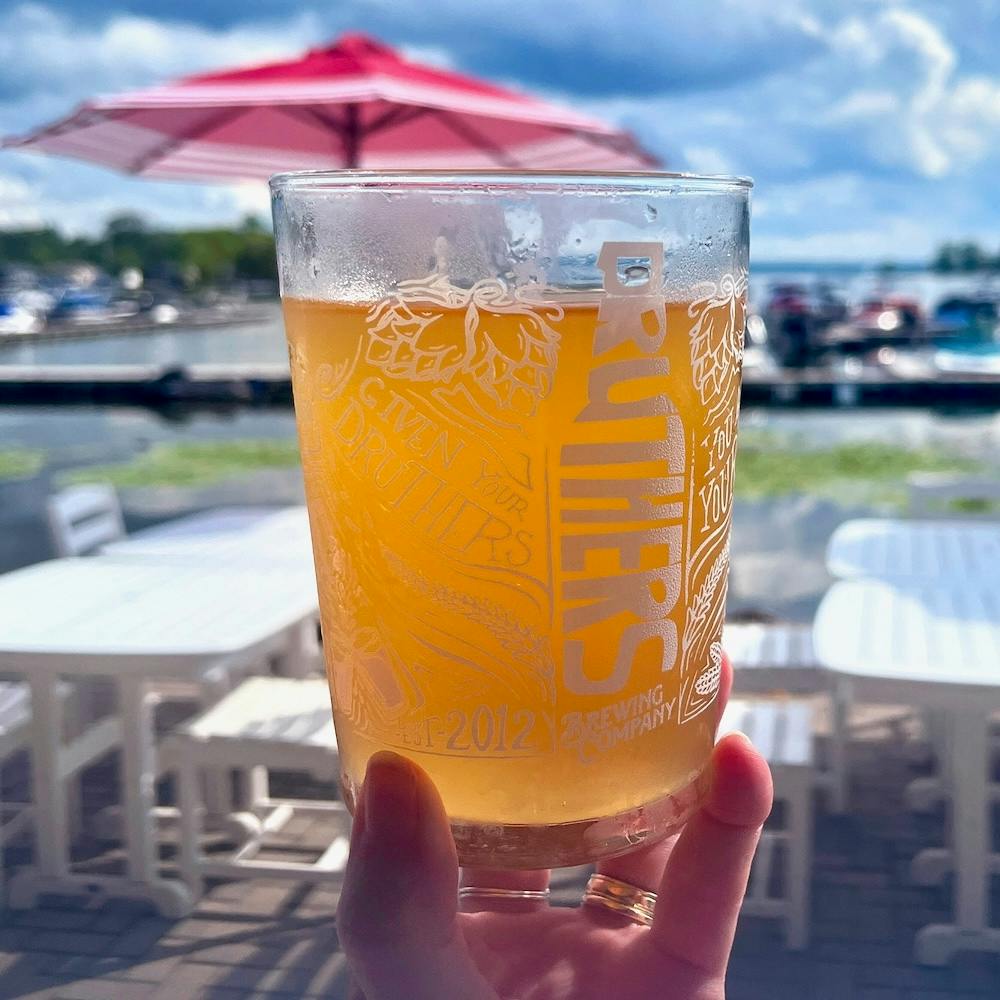 Druther's peach cider with Saratoga Lake behind it