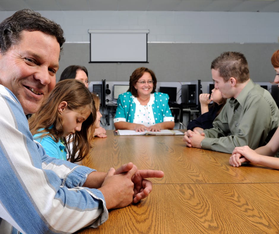 Smiling adults around a school conference table