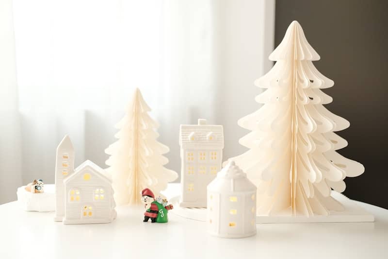 A white table topped with white christmas trees