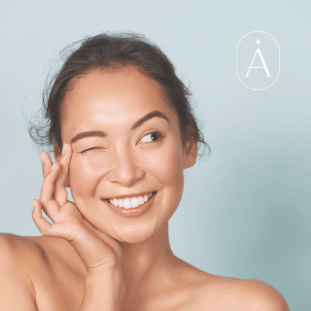 Woman winking and touching her face.