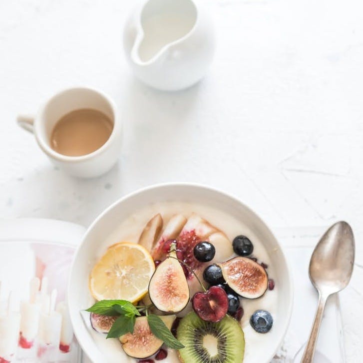 white ceramic plate beside gray steel spoon