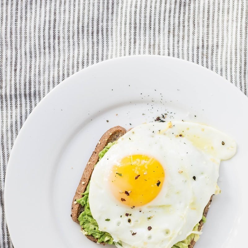 sunny side up egg, lettuce, bread on white ceramic plate