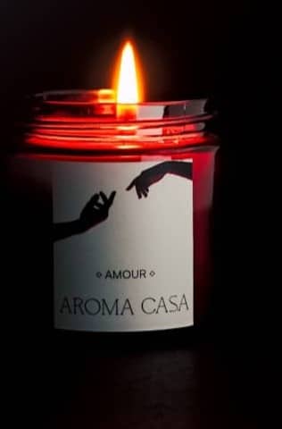 Lit red candle with label on dark background