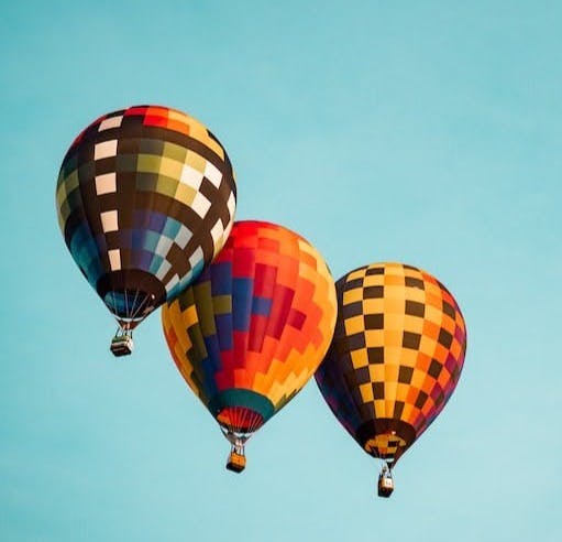 three flying hot air balloons