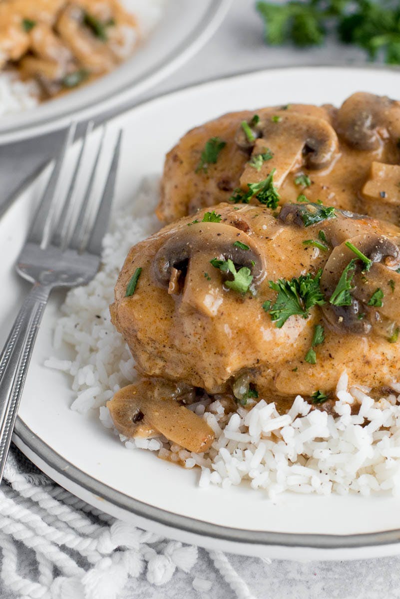 a close-up shot of Instant Pot chicken and mushrooms served over rice and garnished with fresh parsley