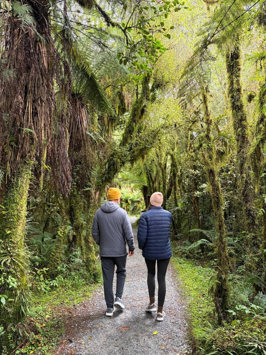 Allan and Katharina walking through a mossy forest on the West Coast of New Zealand's South Island.