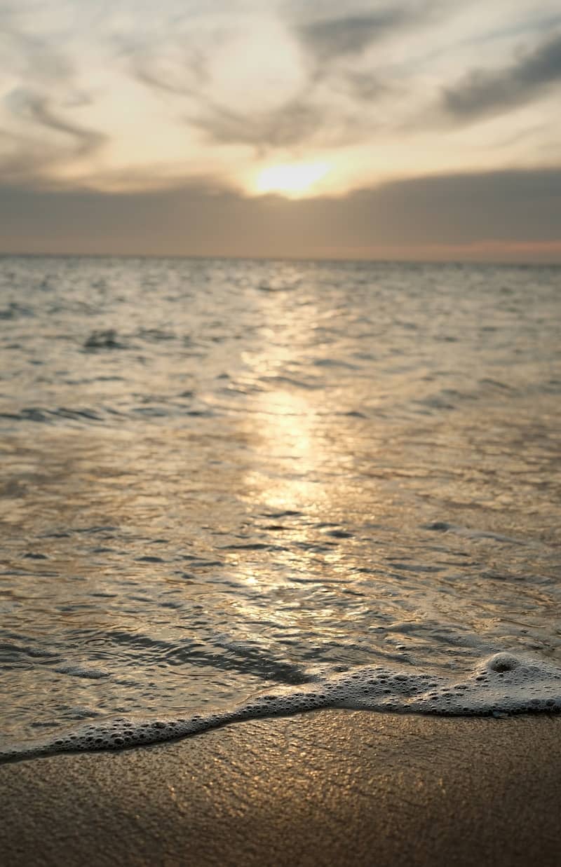 Sunset over a calm ocean with gentle waves