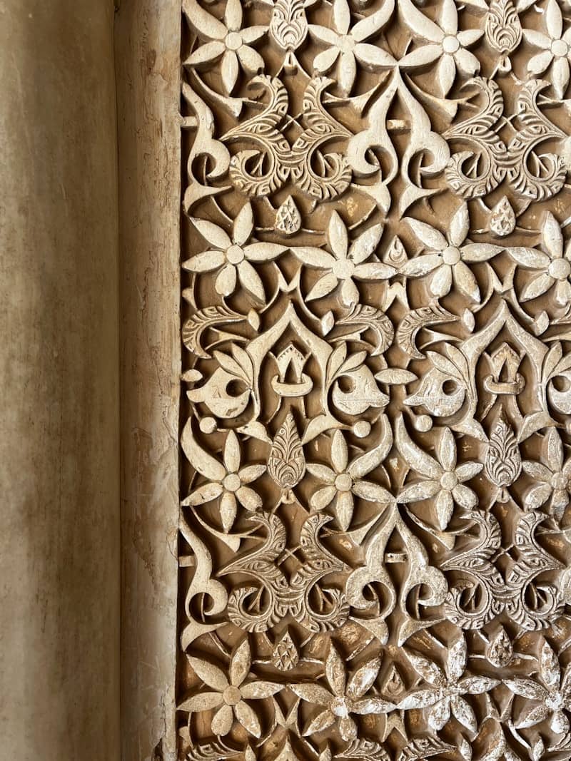 Intricate floral carvings on a textured wall
