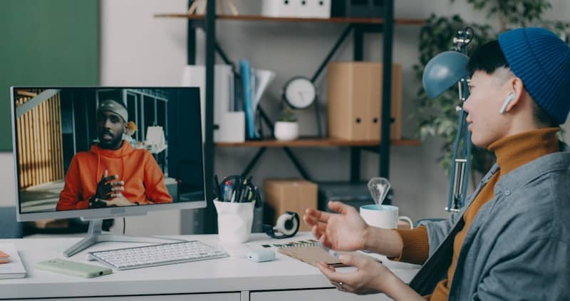 Two people sitting at a desk with a computer