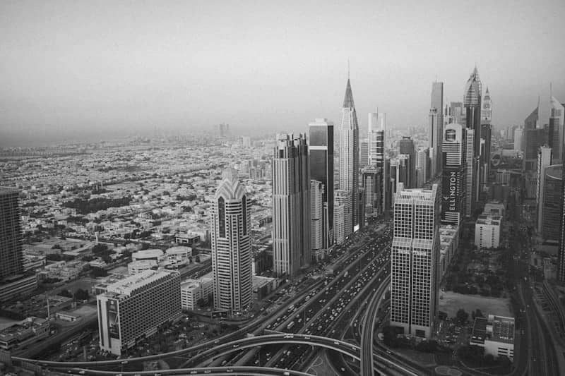 Modern skyscrapers line a busy highway in a sprawling city.