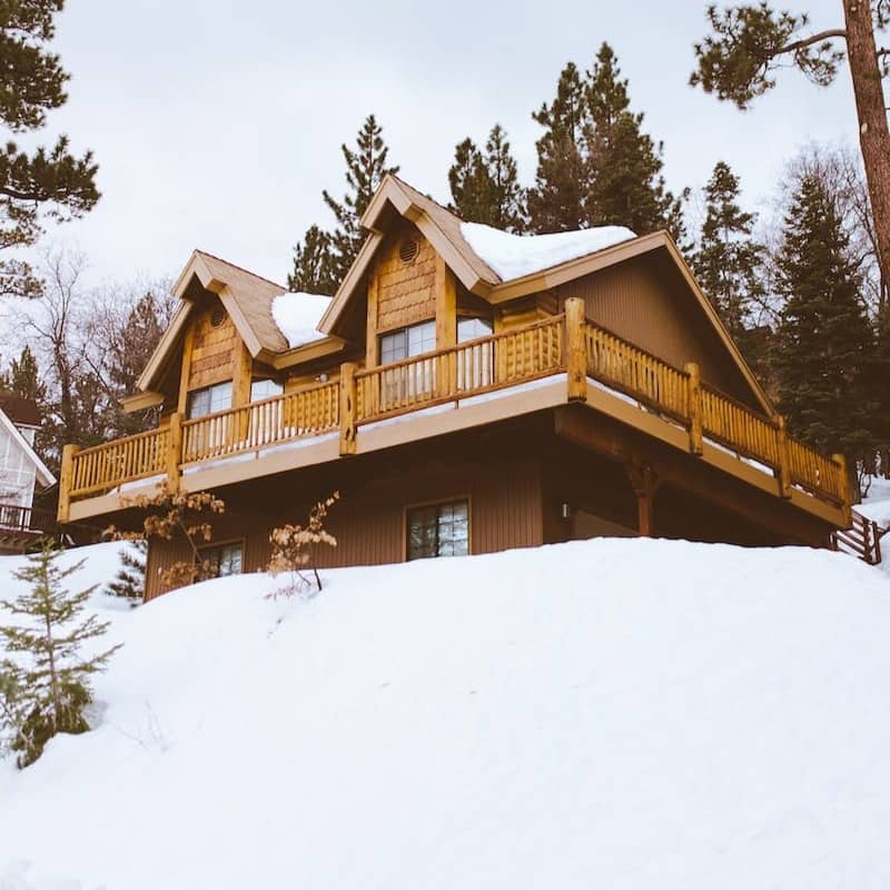 brown house covered and surrounded by snow