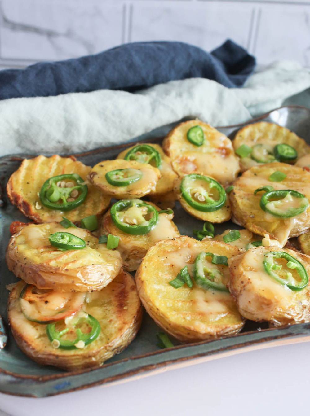 slices of cheesy potatoes with jalapeno slices on top