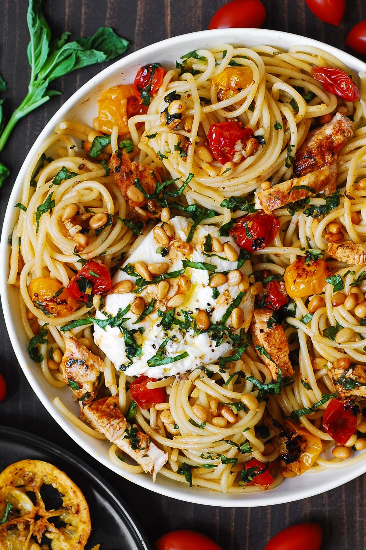 Chicken Spaghetti with Burrata Cheese, Cherry Tomatoes, and Lemon Butter Garlic Sauce on a white plate.