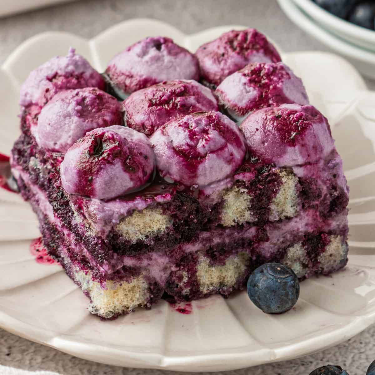 A slice of Blueberry Tiramisu - on a white plate.