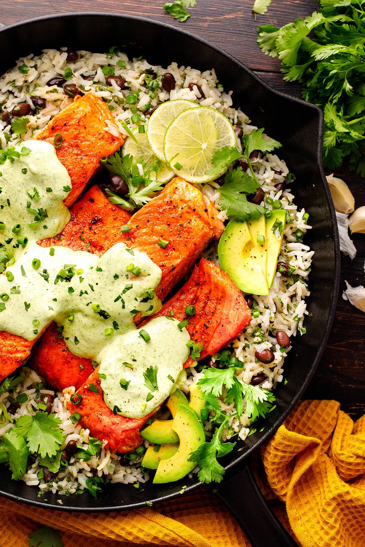 Pan-Seared Salmon and Rice with Cilantro-Lime Crema in a cast iron skillet.