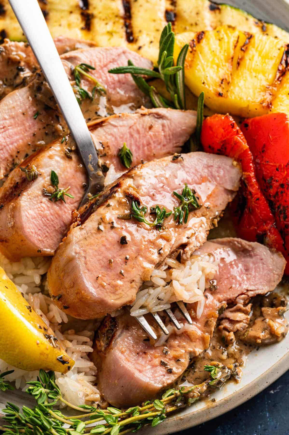 Marinated Grilled Pork Tenderloin (with Pineapple, Veggies, and Garlic Herb Butter Rice) on a plate.