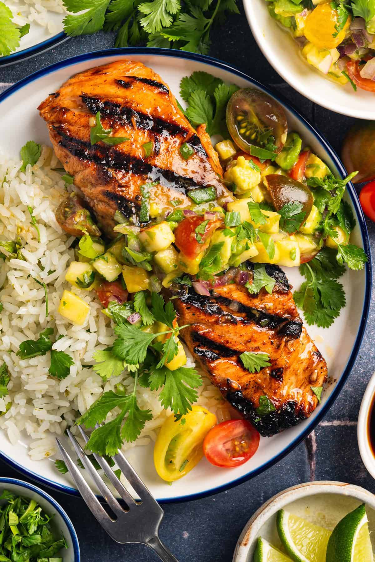 Grilled Salmon with Pineapple-Tomato-Avocado Salsa & Cilantro-Lime Rice on a white plate.