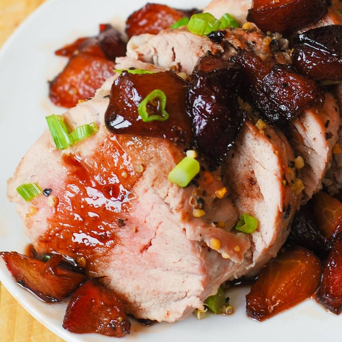 Pork Tenderloin with Sweet Balsamic Plum Sauce on a white plate.