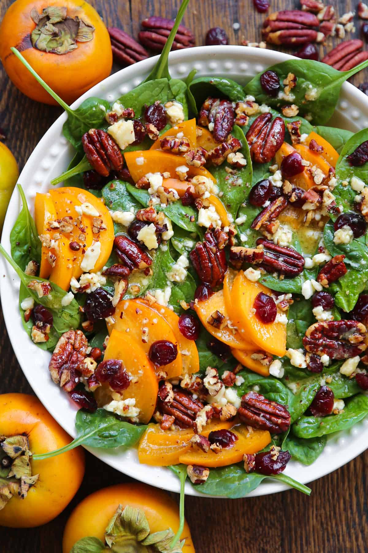 Persimmon Spinach Salad with Honey-Mustard Dressing in a bowl.