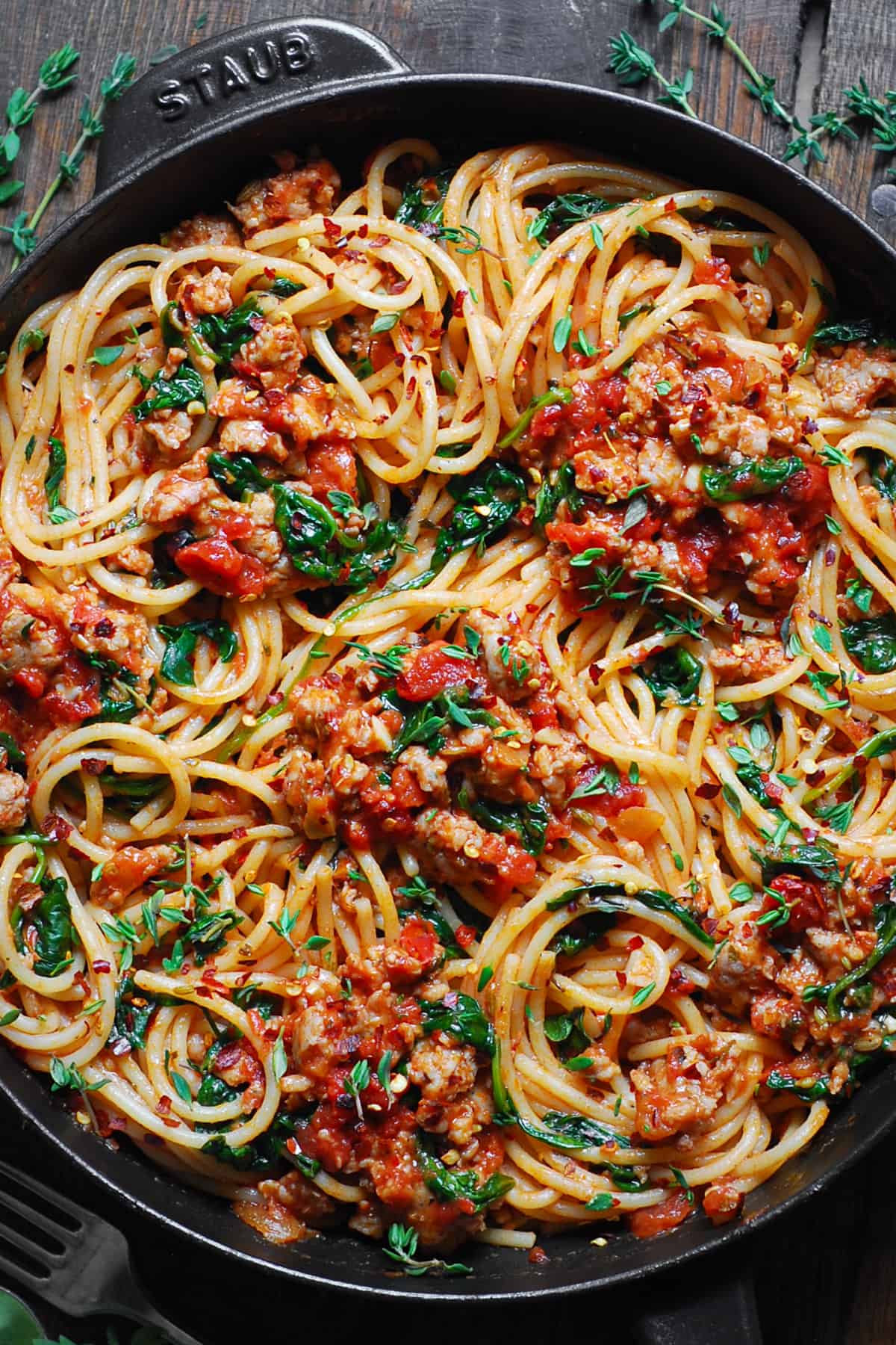 Italian Sausage Spaghetti with Spinach, Fresh Tomatoes, and Marinara Sauce - in a cast iron skillet.