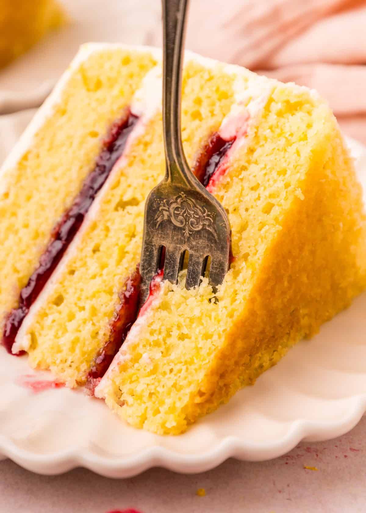 A slice of Lemon Raspberry Cake on a white plate.