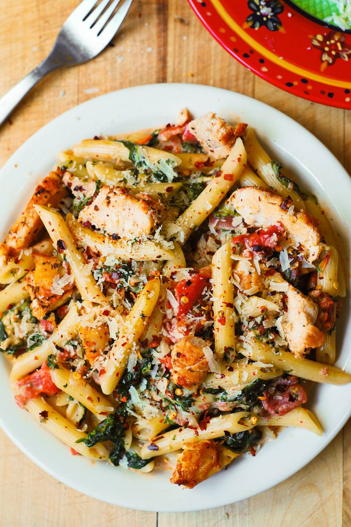 Chicken and Bacon Pasta with Spinach and Tomatoes in Garlic Cream Sauce.