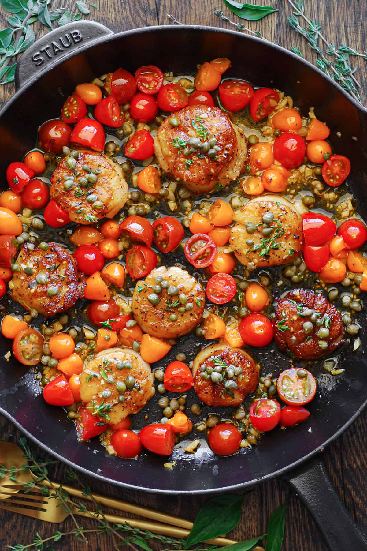 Mediterranean Scallops with Tomatoes, Capers, and Lemon Garlic in a cast iron skillet.