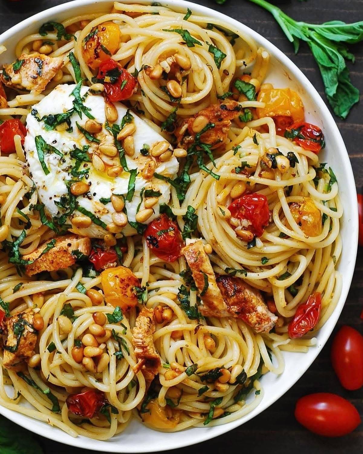 Chicken Spaghetti with Burrata Cheese, Cherry Tomatoes, and Lemon Butter Garlic Sauce on a white plate.