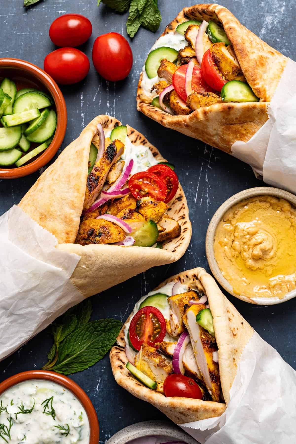 The Best Lemon-Garlic Chicken Pitas with Greek Yogurt Tzatziki, Tomato-Cucumber Salad, & Hummus.