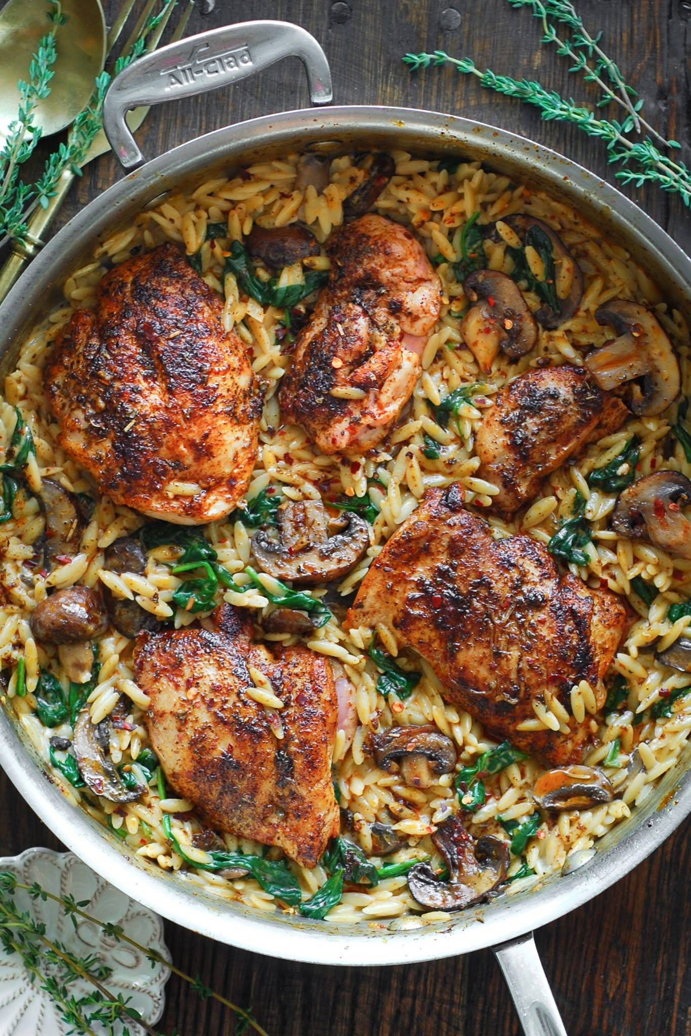 Creamy Chicken Orzo with Spinach, Mushrooms, and Smoked Paprika Cream Sauce in a stainless steel pan.