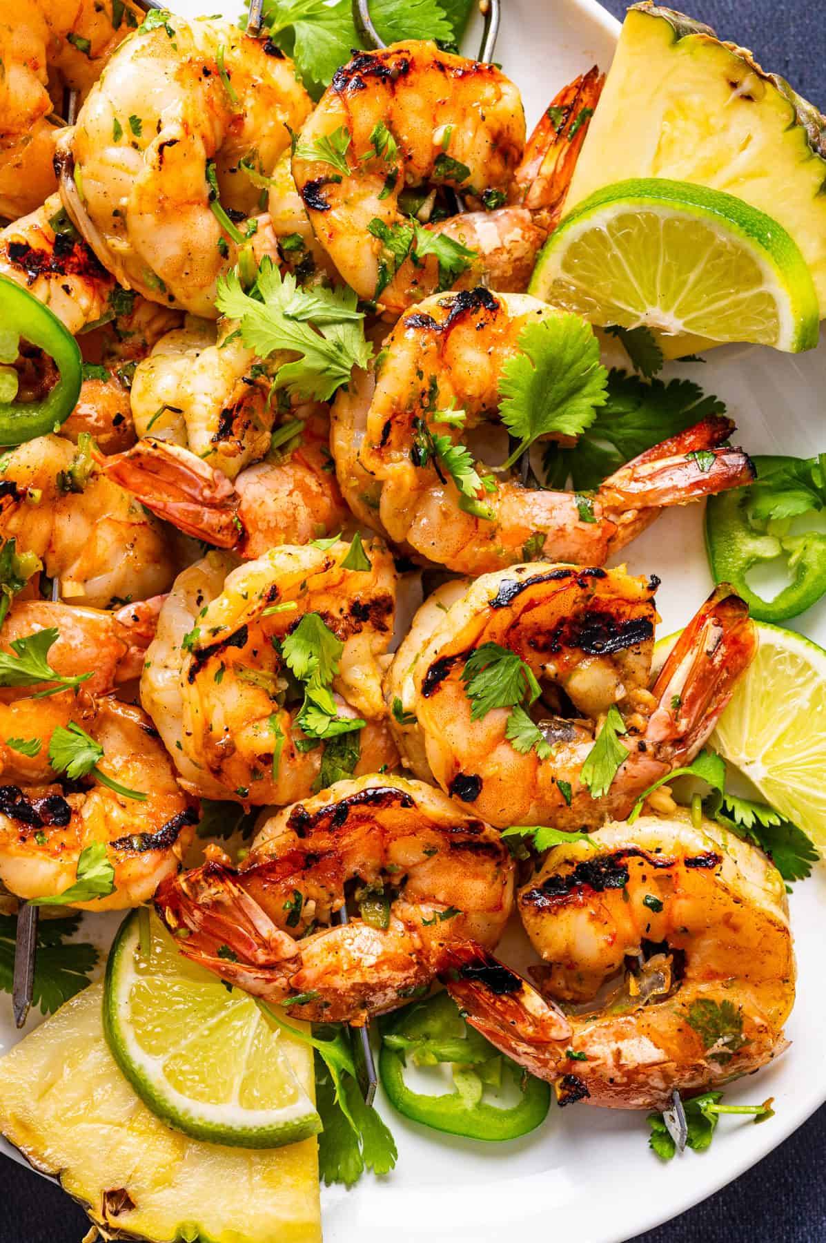 Grilled shrimp skewers on a white plate.