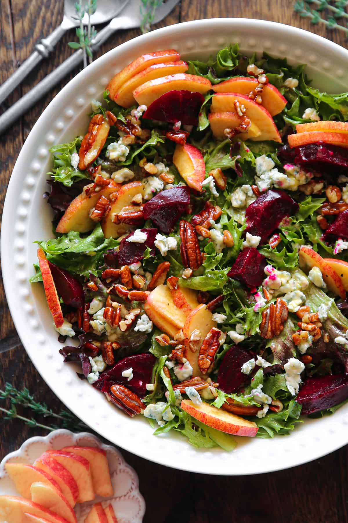 Beet and Apple Salad with Mixed Greens, Pecans, Blue Cheese, and Honey-Lemon Mustard Dressing - in a bowl.