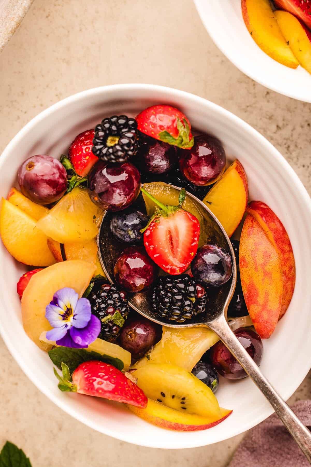Summer Fruit Salad with Peaches and Maple-Lime Dressing in a small white bowl.