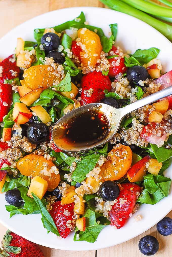 Quinoa Salad with Spinach, Strawberries, Blueberries, and Mandarins on a plate.