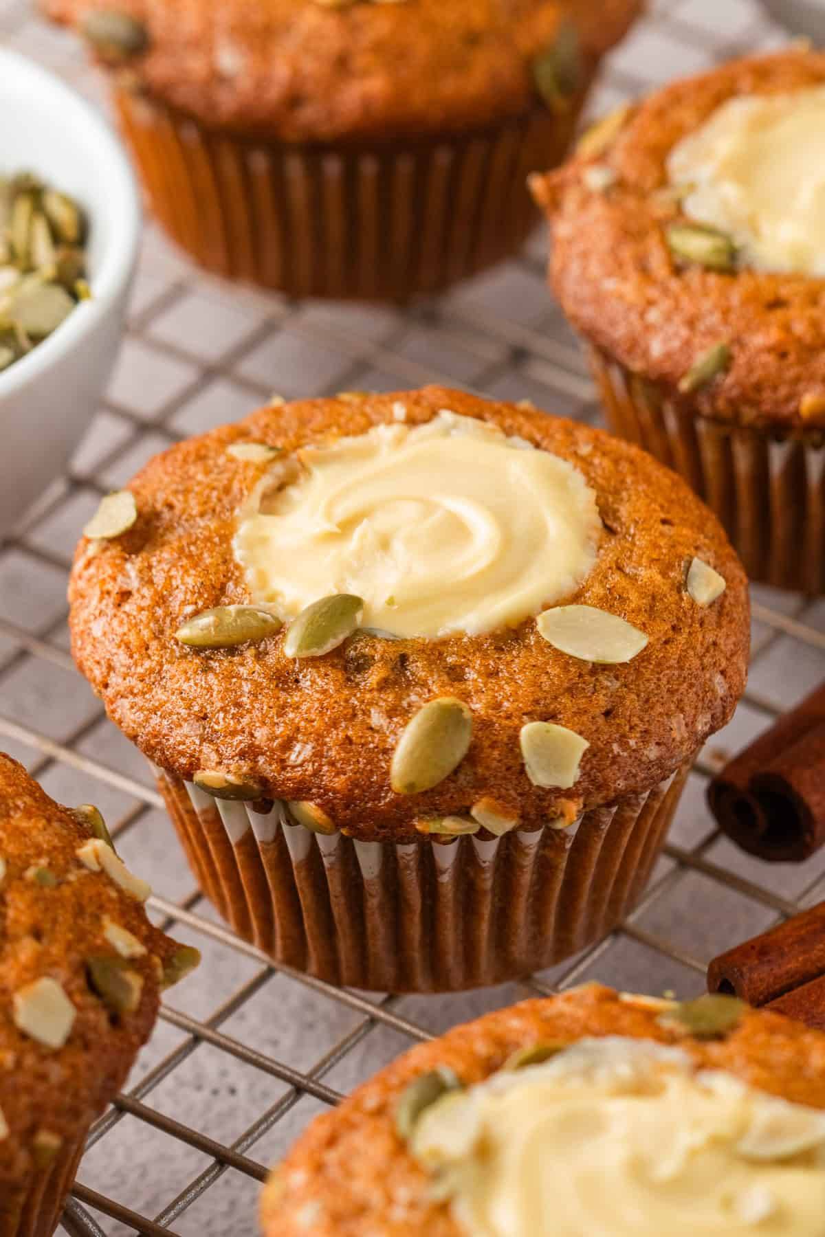 Pumpkin Cream Cheese Muffins with Pepitas (Pumpkin Seeds) on a rack.