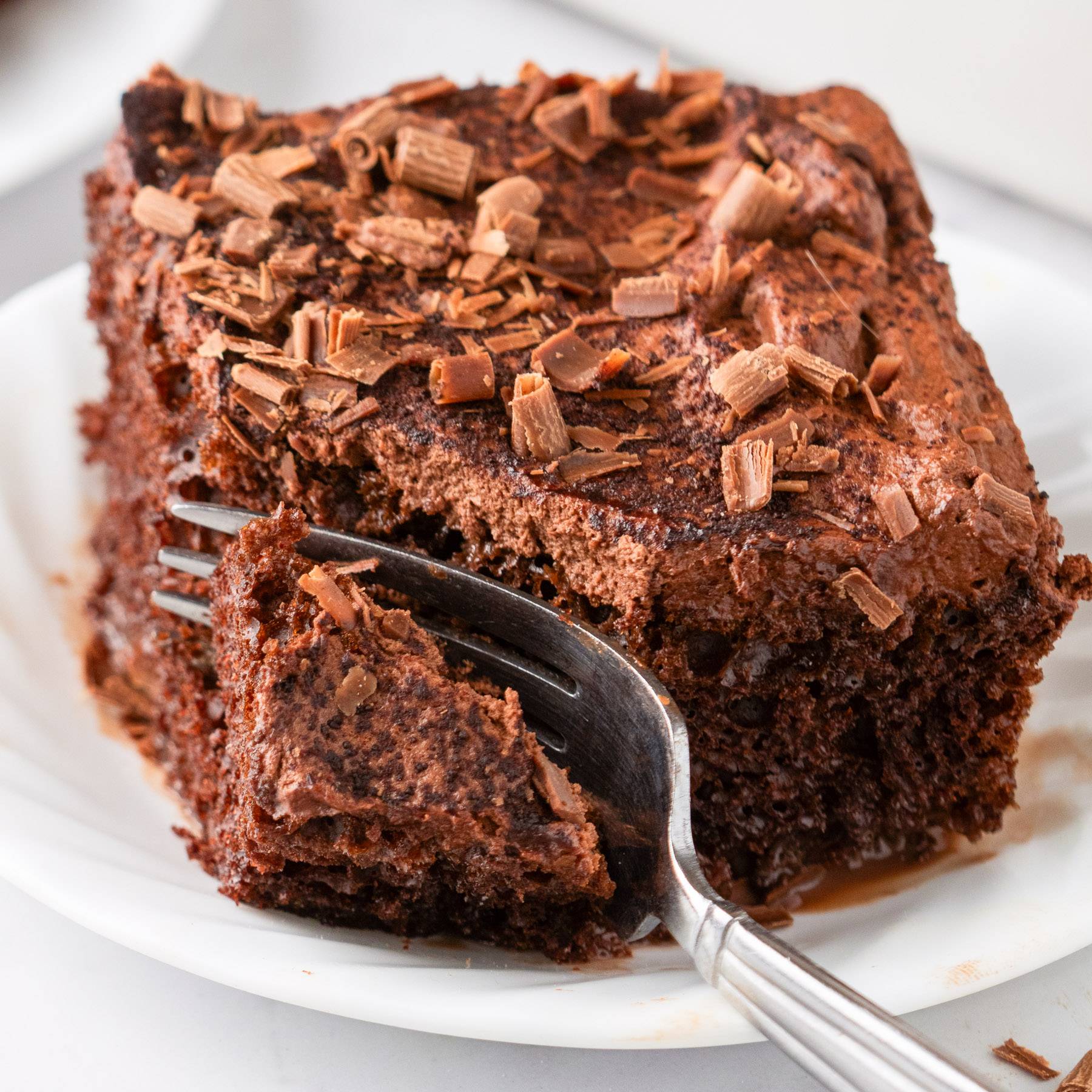 Chocolate Tres Leches Cake (a slice of cake on a white plate).