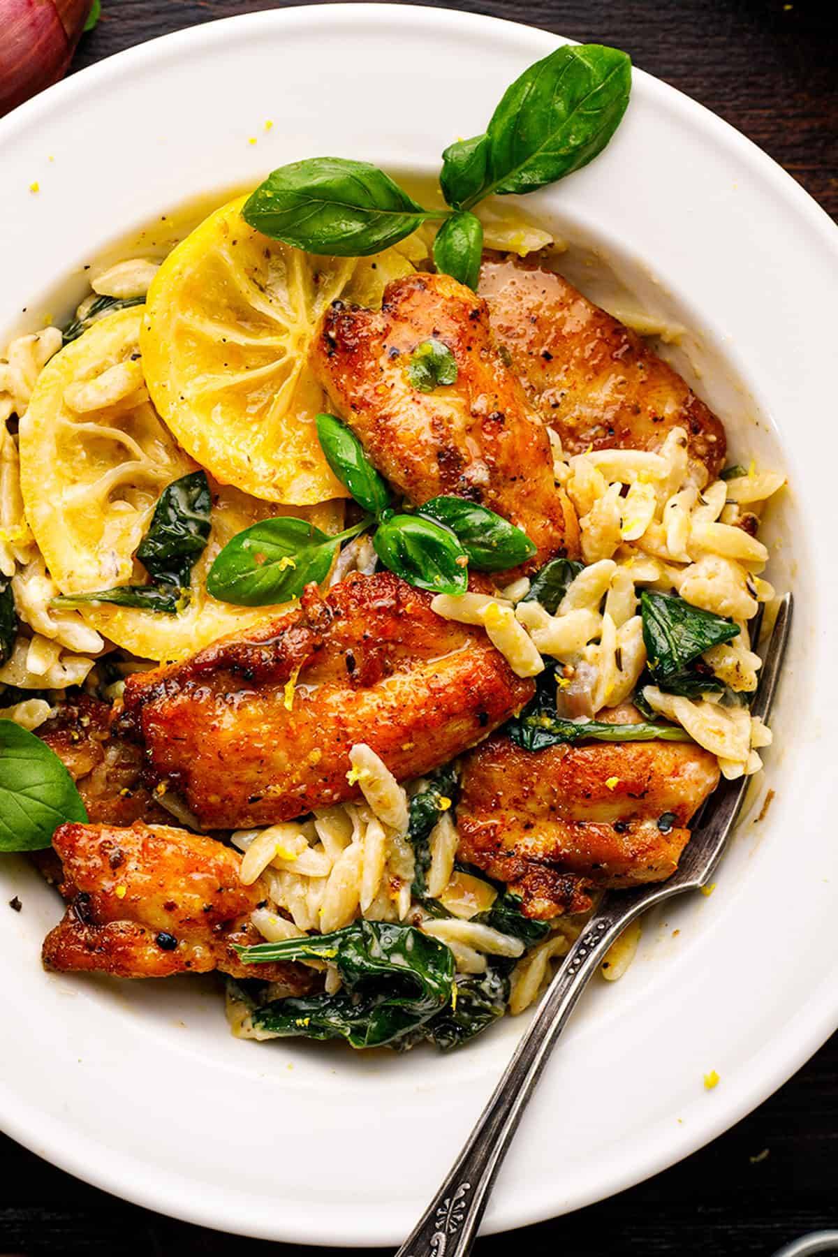 Creamy Lemon Chicken Orzo with Spinach and Parmesan in a white plate.
