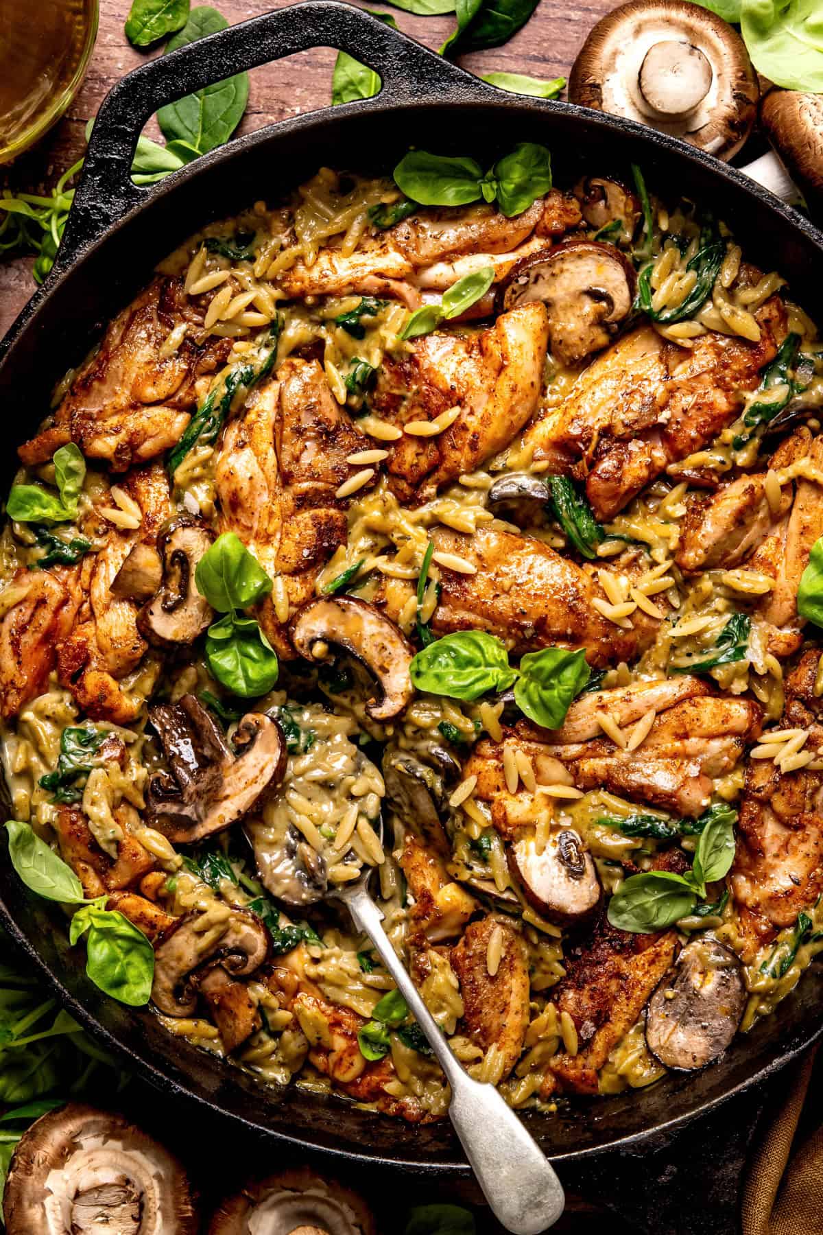 One-Pan Creamy Chicken Orzo with Mushrooms and Spinach in a cast iron skillet.