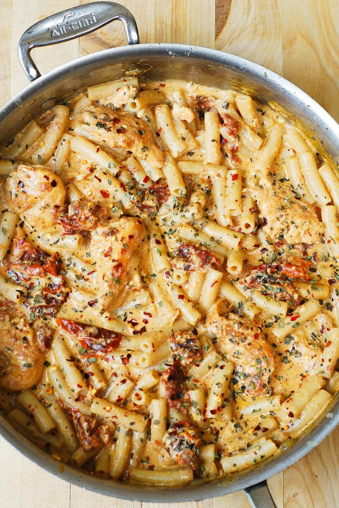 Creamy Chicken Mozzarella Pasta with Sun-Dried Tomato and Basil Sauce - in a stainless steel pan.