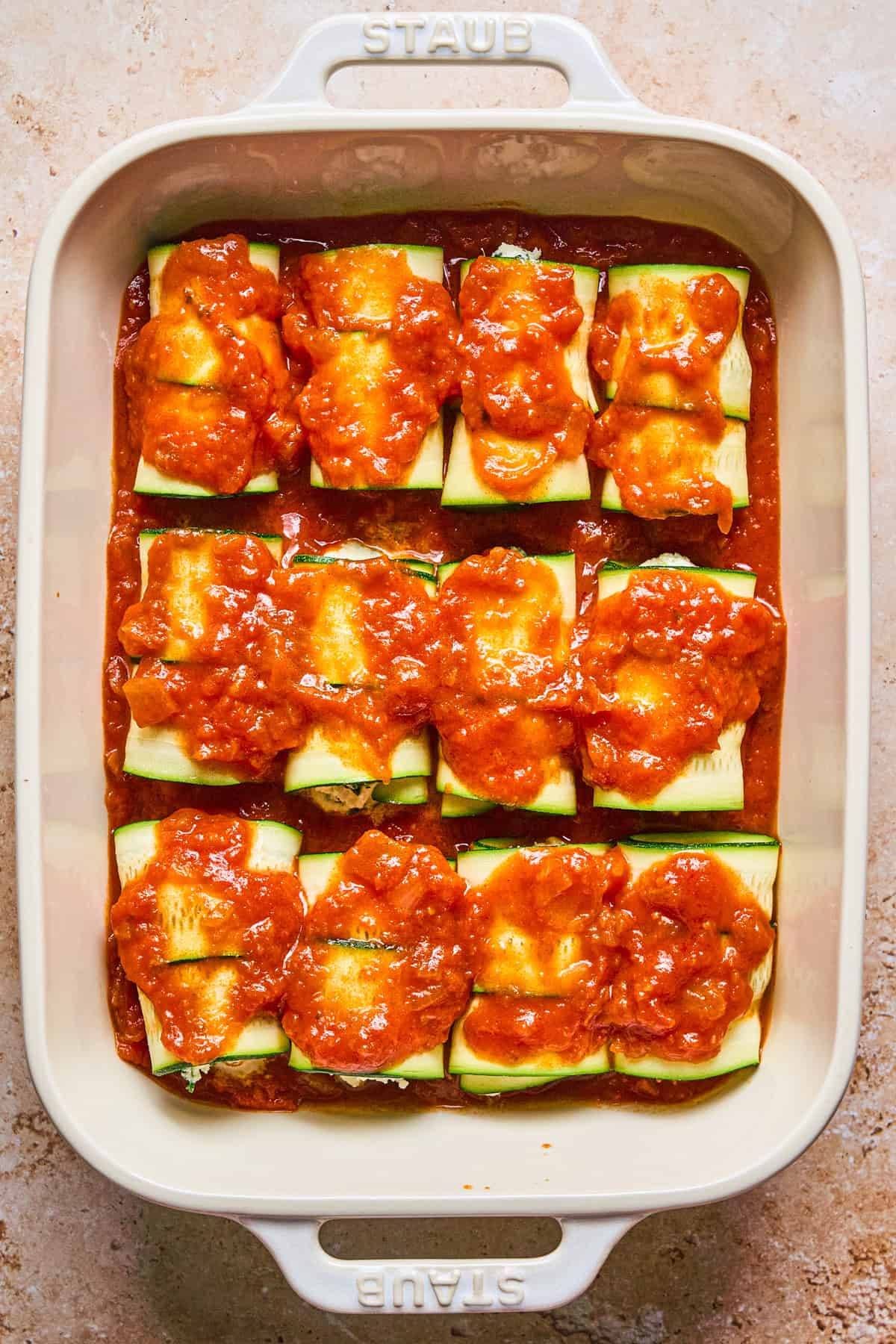Zucchini Rollatini with Spinach and Ricotta in a white casserole dish.