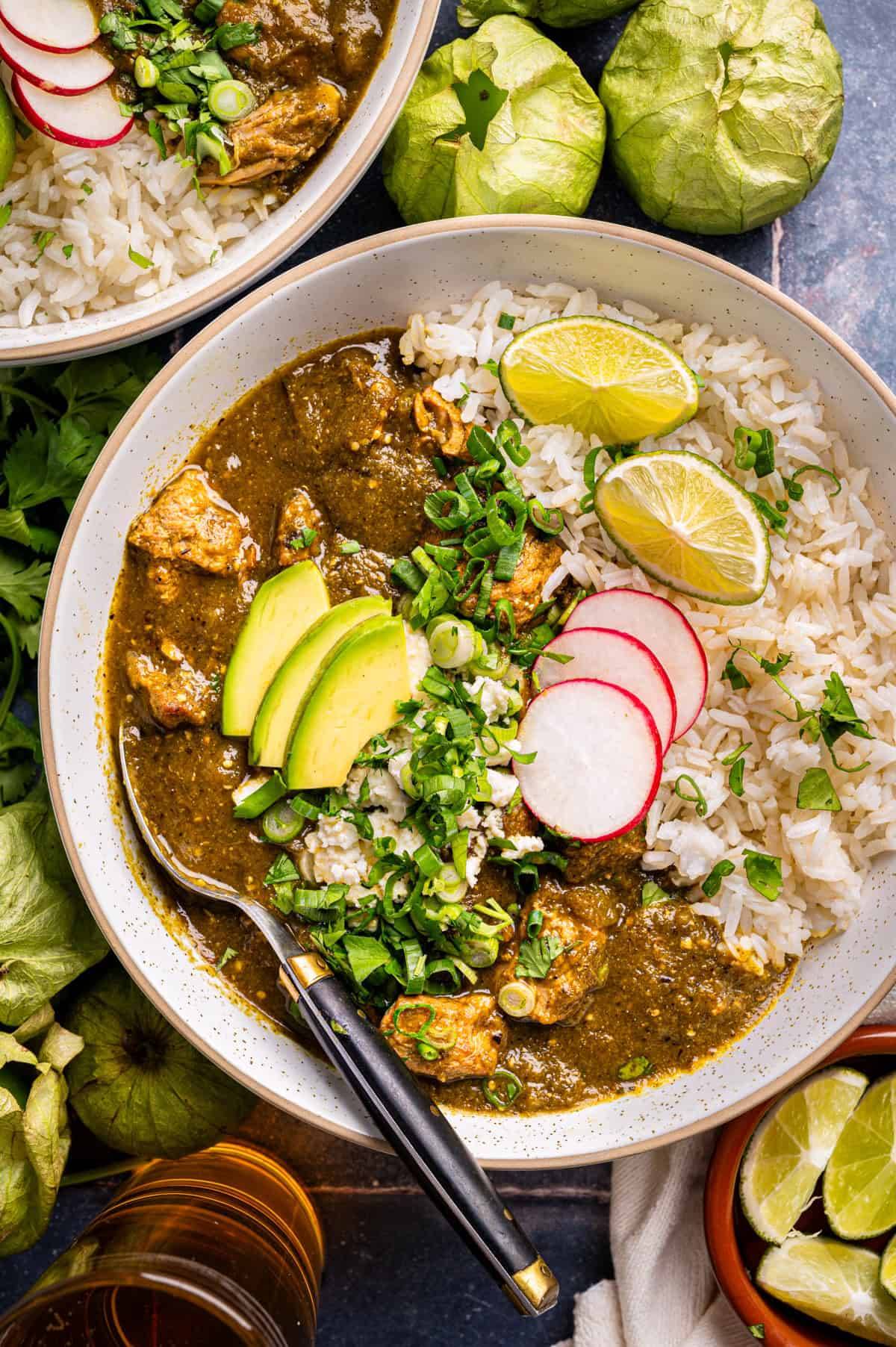 Pork Chile Verde with rice and avocado in a bowl.
