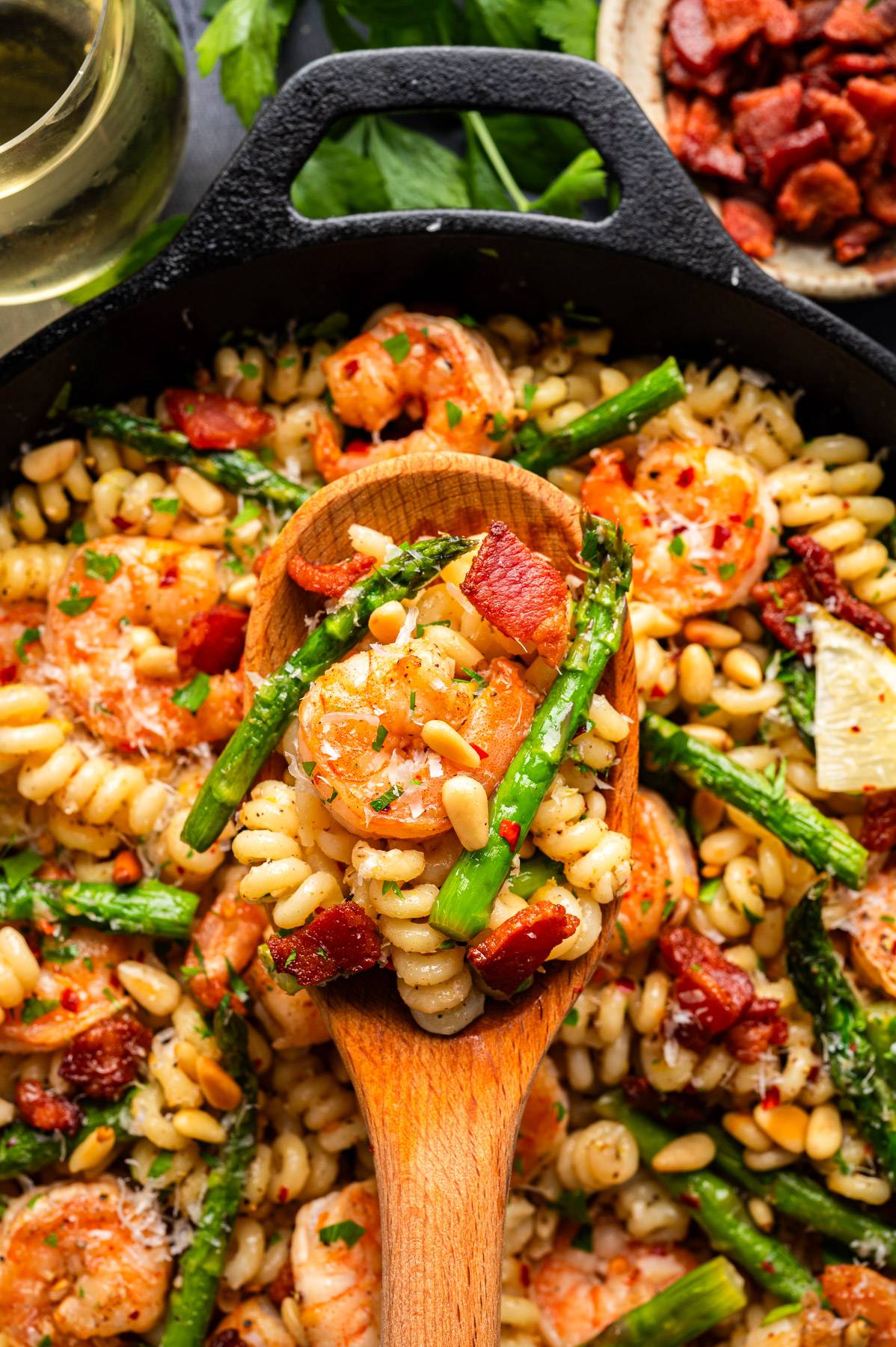 Shrimp Asparagus Bacon Pasta with Pine Nuts and Lemon-Butter Parmesan Sauce in a cast iron skillet.