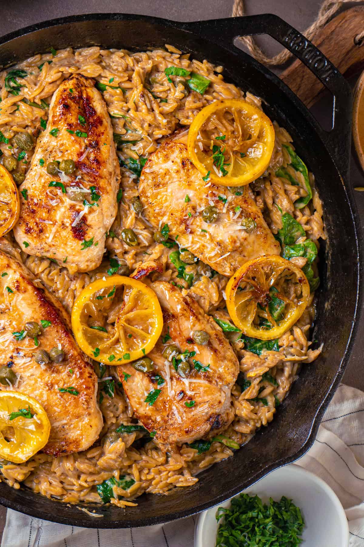 Chicken Piccata Orzo with Spinach, Lemon, and Capers - in a cast iron skillet.