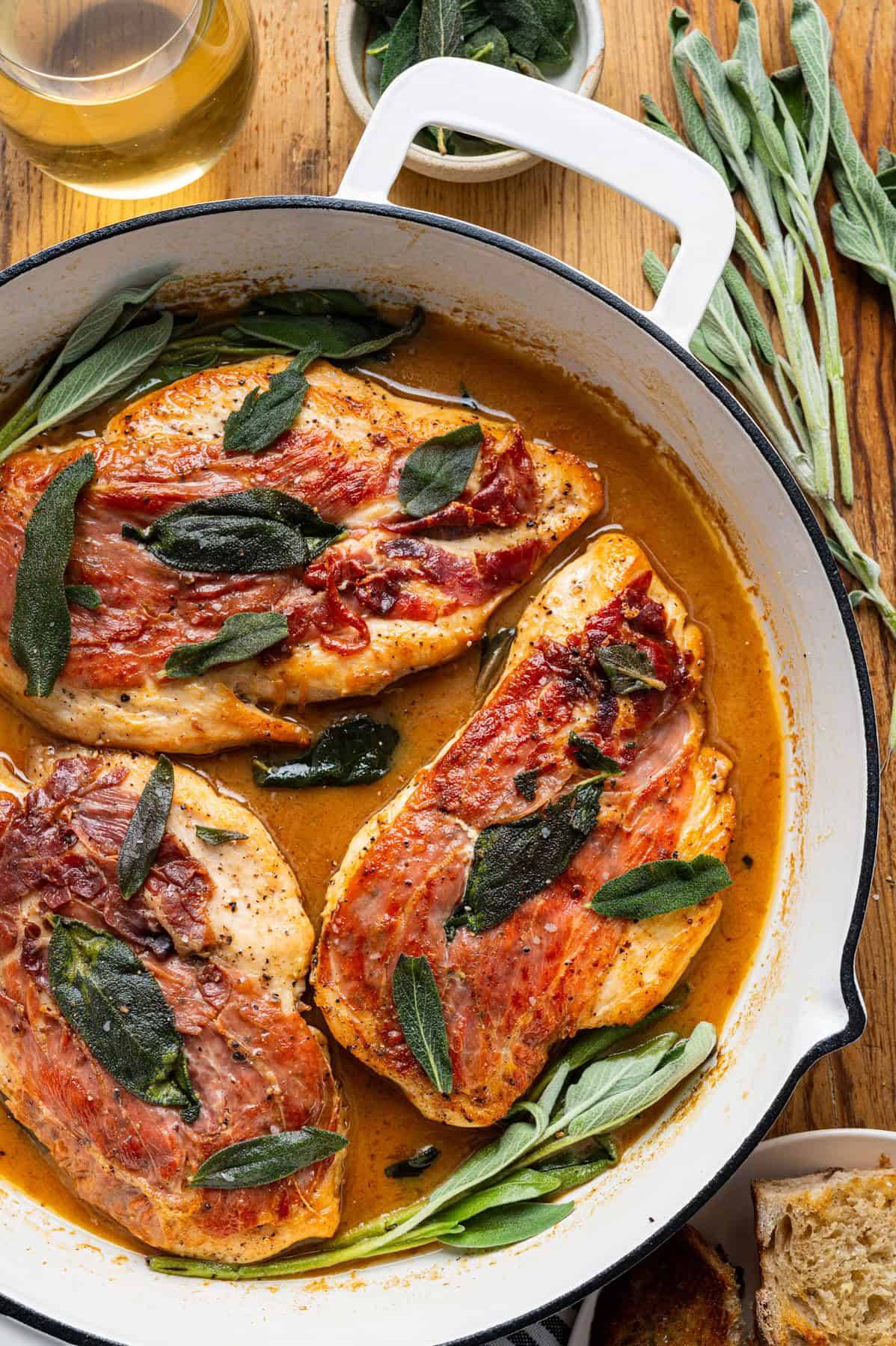 Chicken Saltimbocca (Prosciutto, Sage, and White Wine Butter Sauce) in a white skillet.