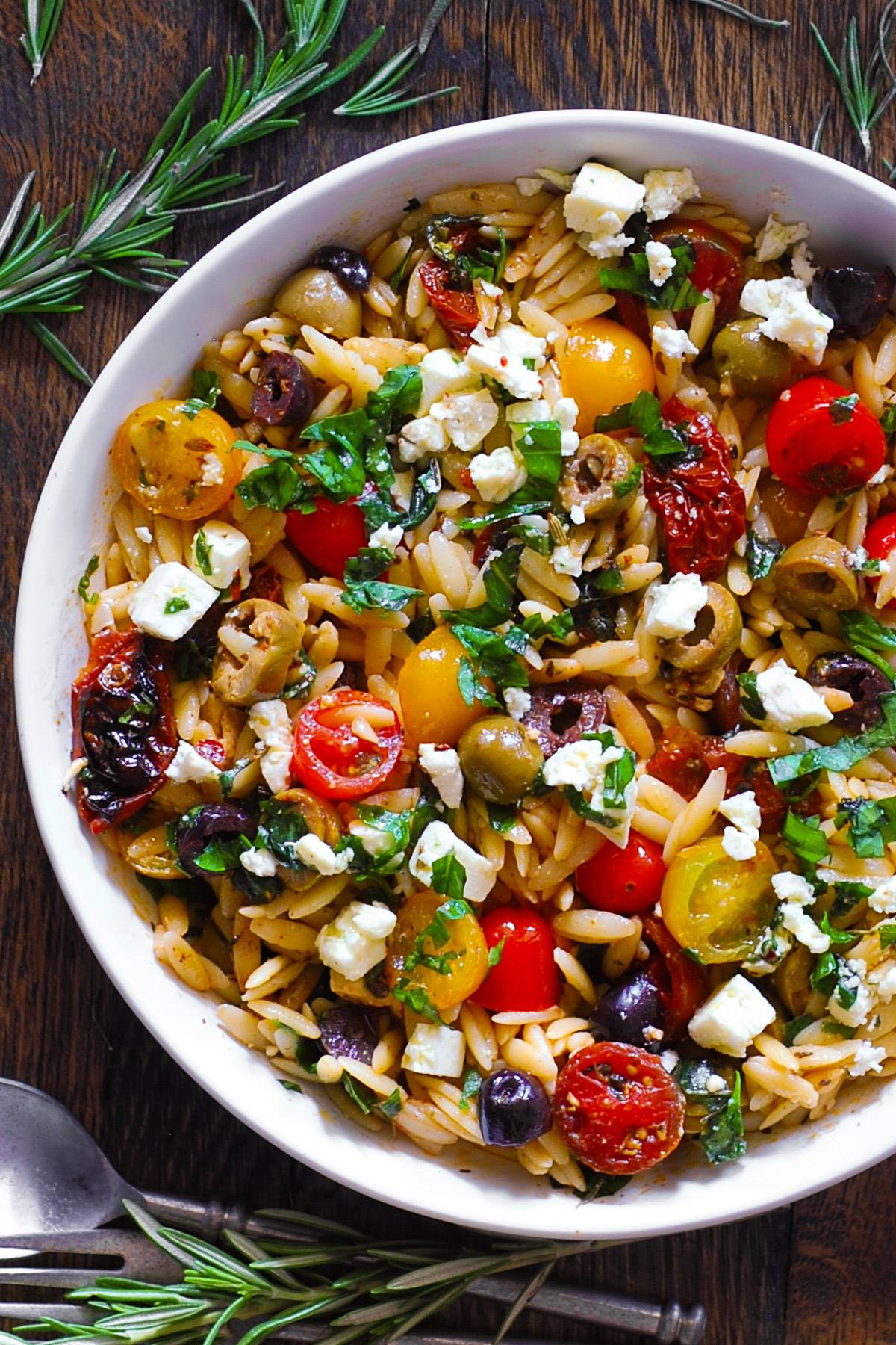 Greek Orzo with Tomatoes, Feta, Olives, and Fresh Basil in a bowl.
